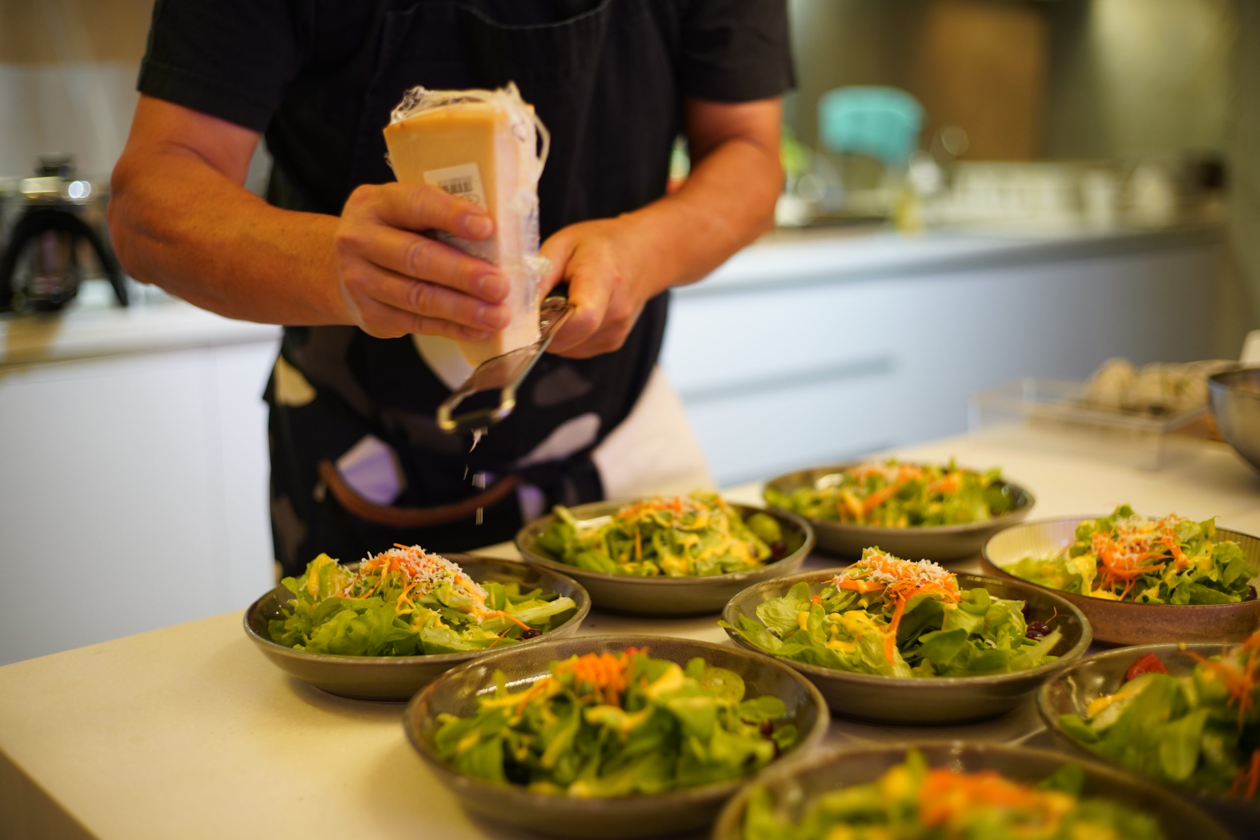 Chef preparing fresh salads from Green Skies’ sustainable farm-to-table produce.